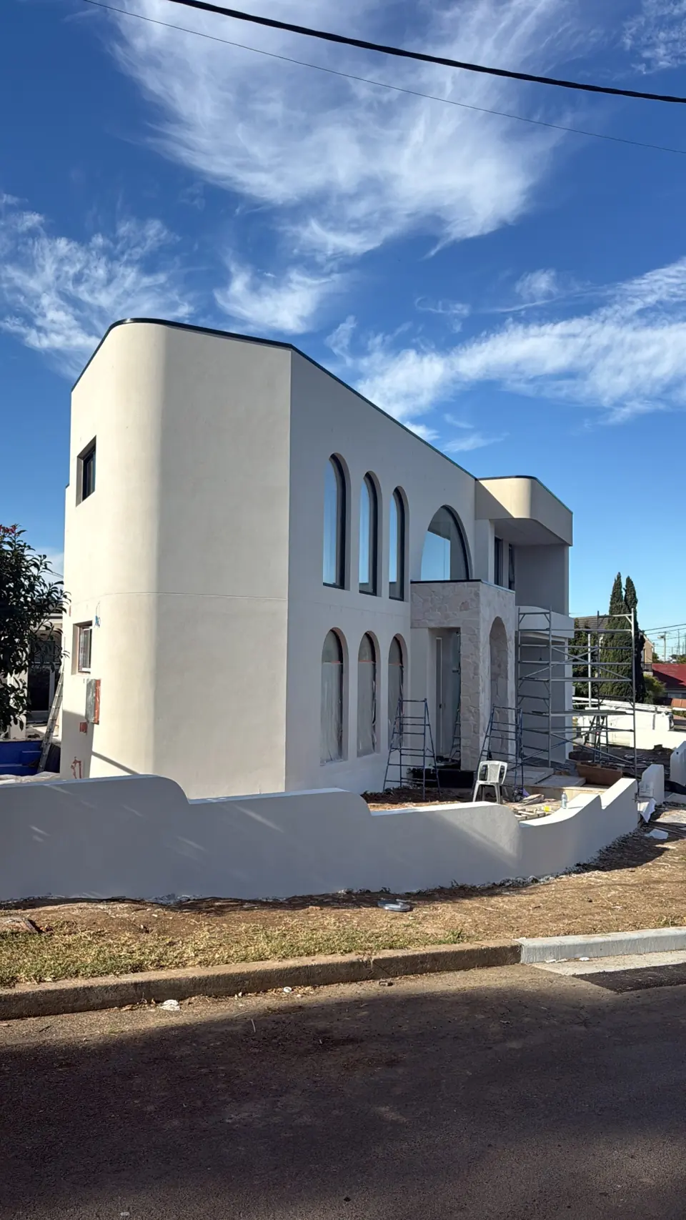 View along the curved facade and arched windows during construction