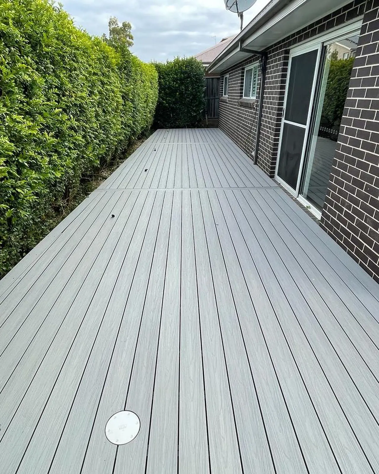 Completed garden deck beside a brick home
