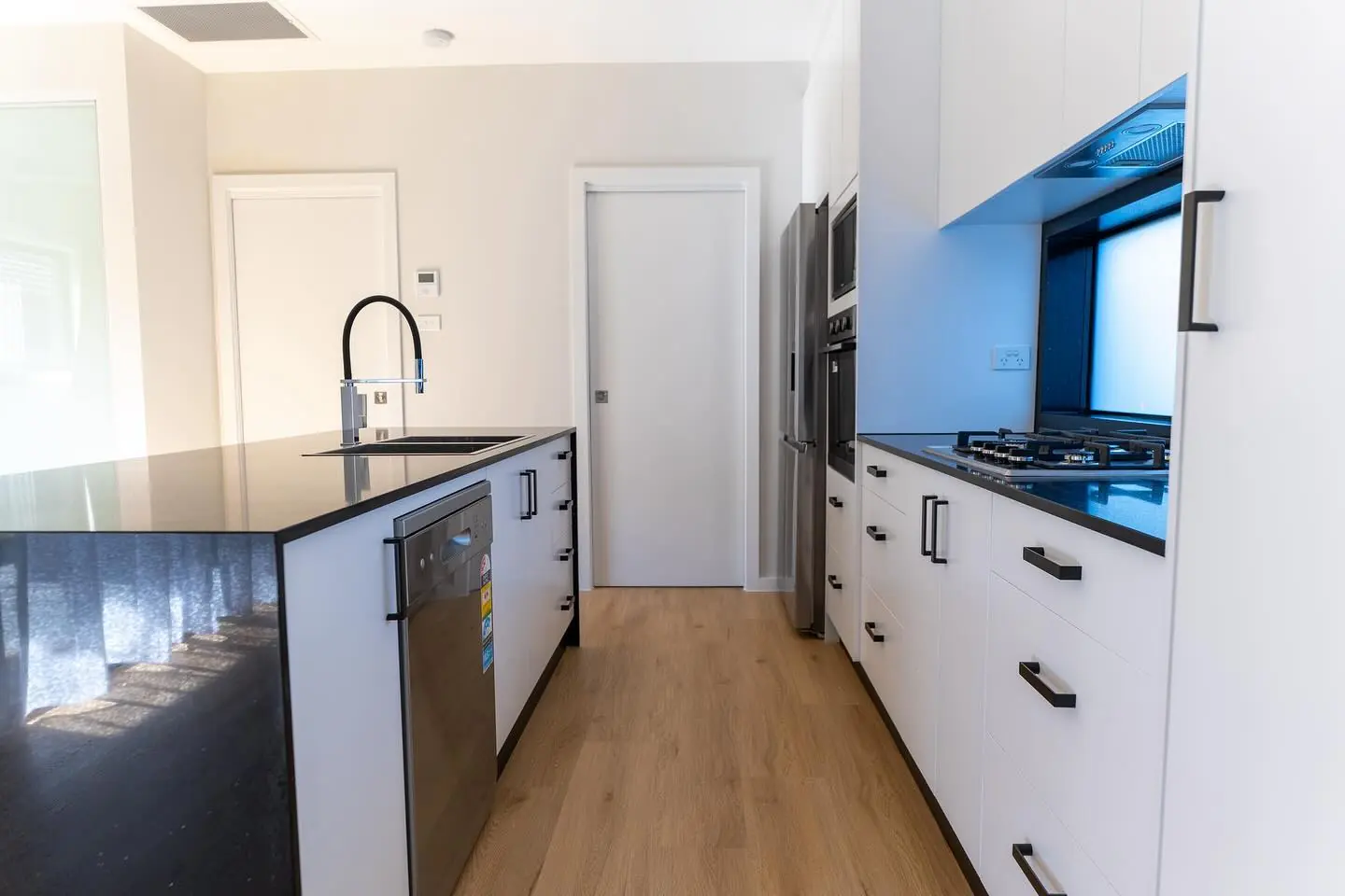 Granny flat interior with timber flooring and fitted kitchen
