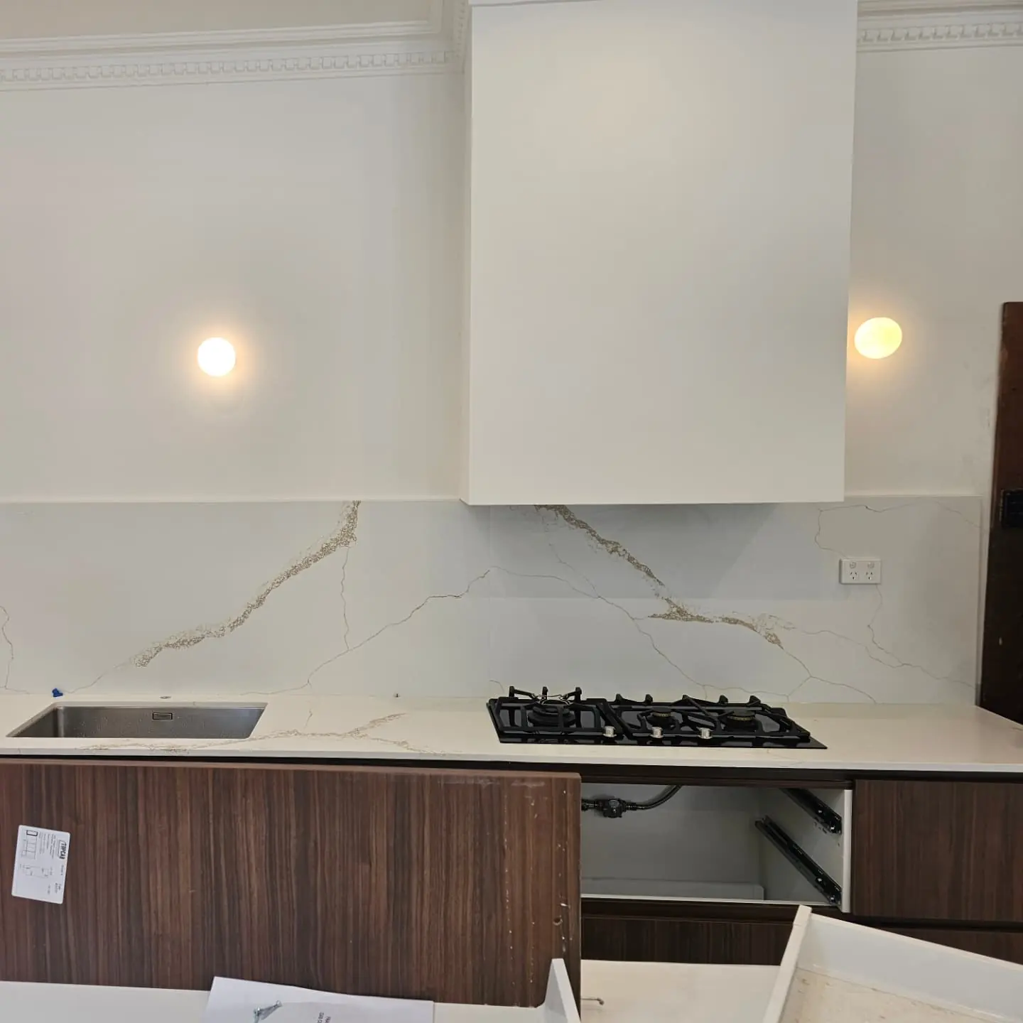 Kitchen joinery, stone splashback and wall lights during renovation