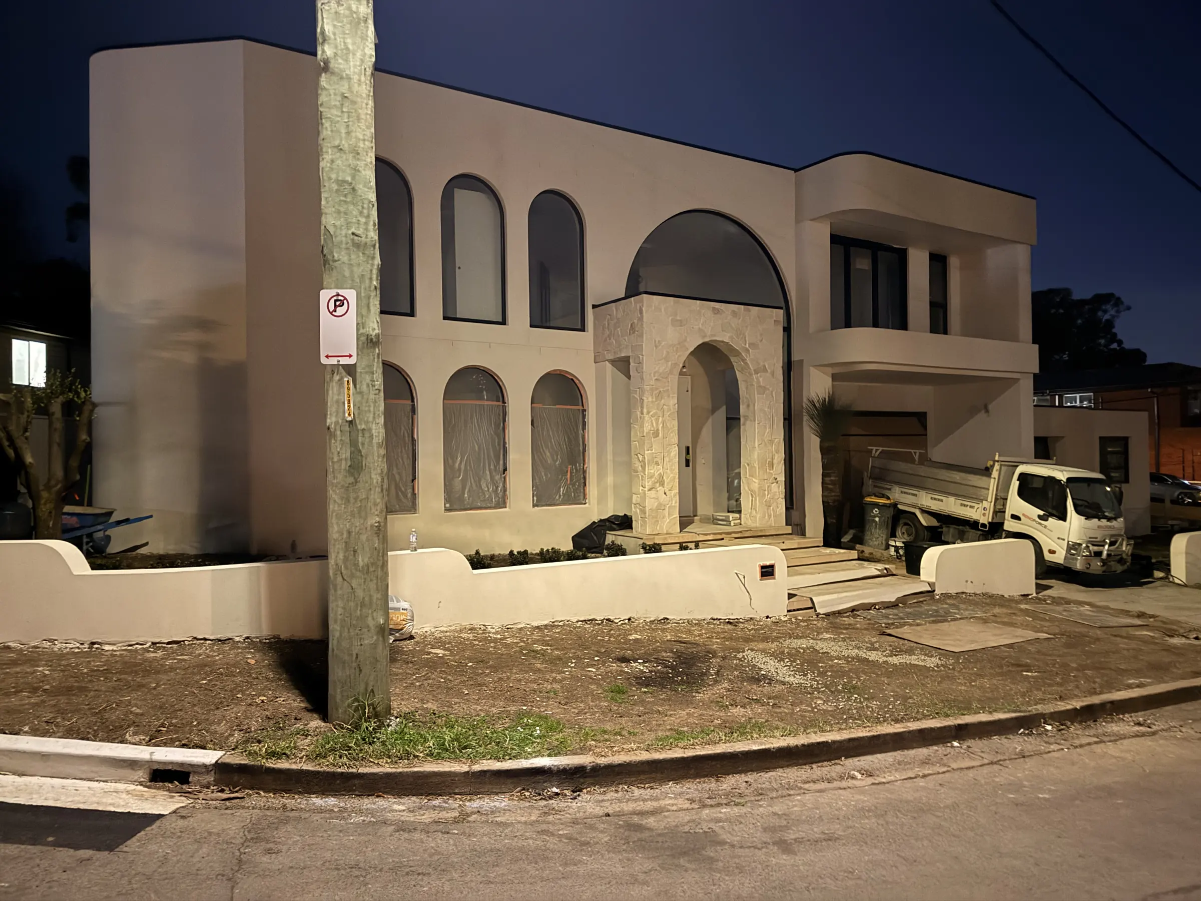 Stone entrance and arched windows photographed at dusk during construction